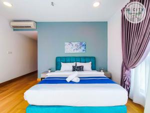 努沙再也Teega Suites by JBcity Home的一间卧室配有一张带蓝色墙壁的大床