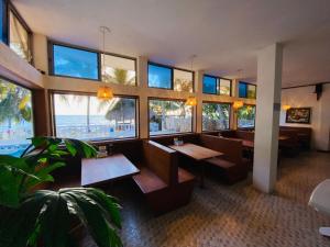 托卢科斯塔琳达酒店的一间设有桌子的餐厅,享有海滩美景