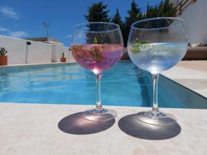 拉斯内格拉斯Casa A.Mar的两个酒杯坐在桌旁的游泳池旁