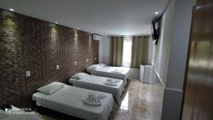 伊瓜苏hotel nacional palace的带三张床和砖墙的房间
