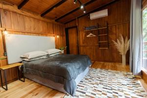 本图贡萨尔维斯Cabana Grafe的卧室配有一张床铺,位于带木墙的房间内