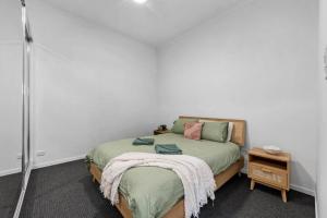 雷德克利夫Bay Vista Two Bedroom Waterfront Apartment的一间卧室配有一张床铺,床上有毯子