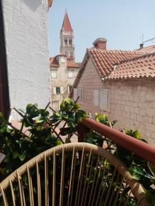 特罗吉尔Apartments & Rooms Trogir Stars FREE PARKING的一个带植物和钟楼的阳台