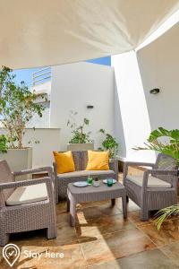 拉巴特Stayhere Rabat - Agdal 3 - Prestige Residence的庭院配有椅子、沙发和桌子