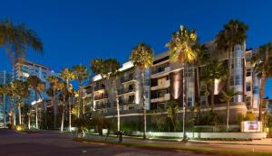 洛杉矶Suites in MDR-Venice with Pool, GYM & HotTub的街道前方有棕榈树的建筑
