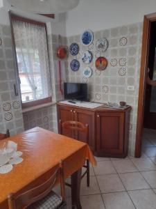 奥斯塔Casa vacanze Gianluca的厨房配有桌子和盘子,墙上挂着