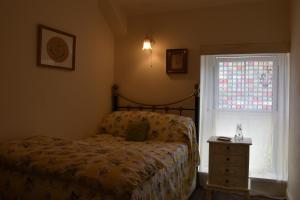 TreharrisY Bwthyn Bach - Taff Trail的一间卧室设有一张床和一个窗口