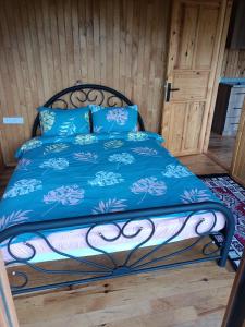 加济帕夏Hergül Holiday Village的一张带蓝色棉被和蓝色枕头的床