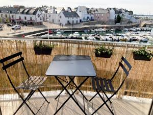 基伯龙Studio du vieux port的一个带海港的阳台,配有一张桌子和两把椅子