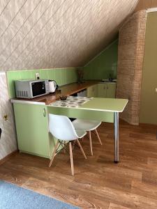 KotowskМіні-готель的绿色厨房配有桌子和微波炉