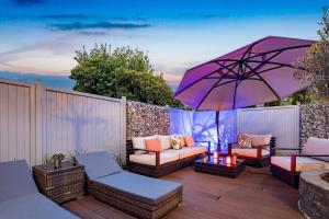 朗格奥克罗格诺德希酒店的庭院配有紫色雨伞、椅子和桌子