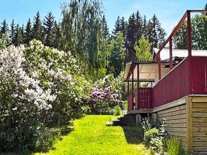 南泰利耶Holiday home Södertälje的一座花园,花园内有红色的建筑和一些树木