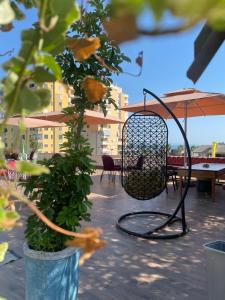 都拉斯Top view hostel的庭院配有桌椅和遮阳伞。