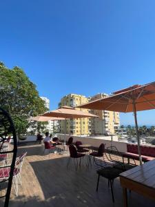 都拉斯Top view hostel的一个带桌椅和遮阳伞的庭院