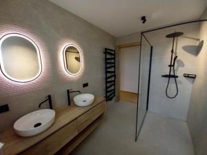 圣沃尔夫冈Wolf & Schaf Apartments的浴室设有2个水槽、2面镜子和淋浴。