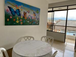 图卢阿Hotel Lina Maria的一间设有桌子和蝴蝶绘画的用餐室
