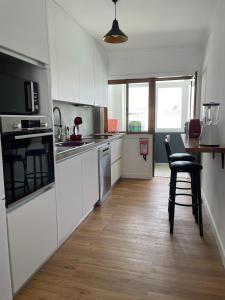 马托西纽什Matosinhos Terrace Apartment的厨房配有白色橱柜和桌椅