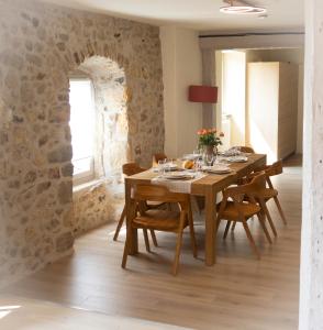 克吕塞耶Chic Campaign - Luxe and confort Lac et Montagne的一间带木桌和椅子的用餐室