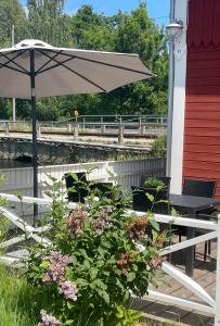 AsarumLovely Waterfront Cottage near Karlshamn的天井配有桌子、雨伞和鲜花