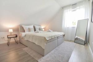 比勒费尔德Luftig, leicht & lebensfroh - Loft - Wifi - TV的白色卧室设有一张大床和镜子