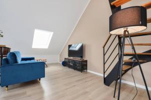 比勒费尔德Luftig, leicht & lebensfroh - Loft - Wifi - TV的客厅配有蓝色的沙发和电视