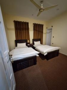 罕萨Royal's Villa by Premiere Inn, Hunza的两张睡床,位于带喷雾器的房间