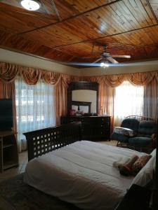 LobatseTjibelu's Nest Guest Home的一间卧室设有一张带木制天花板的大床