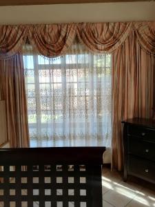 LobatseTjibelu's Nest Guest Home的一间卧室设有大窗户和窗帘