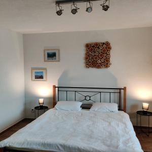 斯皮什新村Nest的一间卧室,配有一张带两盏灯和一堆木柴的床