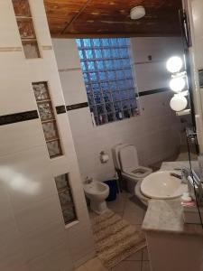 LobatseTjibelu's Nest Guest Home的一间带卫生间和水槽的浴室,并设有一个窗户
