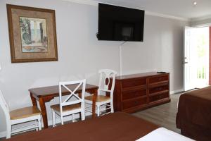 大洋城The Burgundy Inn Hotel and Apartments的一间卧室配有书桌、一张床和一个梳妆台