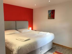 博德明Woodpecker Glamping Cabin的一间卧室配有一张红色墙壁的床
