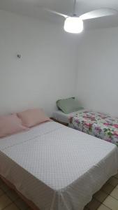 累西腓SUITE e QUARTOS -1 SUITE COM BANHEIRO PRIVATIVO - 2 QUARTOS DUPLOS COM BANHEIRO COMPARTILHADO的一间卧室配有一张床和吊扇