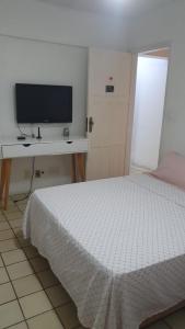 累西腓SUITE e QUARTOS -1 SUITE COM BANHEIRO PRIVATIVO - 2 QUARTOS DUPLOS COM BANHEIRO COMPARTILHADO的一间卧室配有一张床和一张书桌上的电视