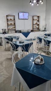 圣地亚哥ICCE HOTEL的用餐室配有蓝色桌子和白色椅子
