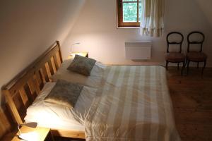 纳文丘夫Dom w Jaśminach的一间卧室配有一张带两把椅子的床和一扇窗户