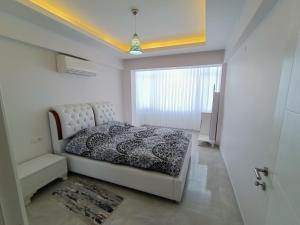 库萨达斯Flat For Rent At The City Center Of Kuşadası的白色的卧室设有床和窗户