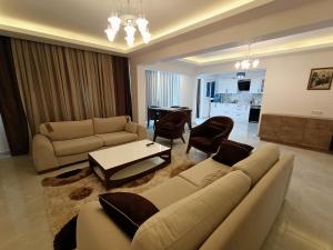 库萨达斯Flat For Rent At The City Center Of Kuşadası的客厅配有沙发和桌子