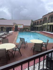 Mount PleasantSureStay Hotel by Best Western Mt Pleasant的享有带桌椅的游泳池的景致。
