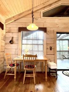 Tellico PlainsCrazy Bear - Motorcycle Friendly Home with Hot Tub and Grill的一间带桌子和两把椅子的用餐室