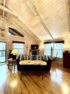 Tellico PlainsCrazy Bear - Motorcycle Friendly Home with Hot Tub and Grill的客厅配有沙发,房间设有木制天花板