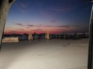 旧瓦马Camper Niklas的日落时在海滩上放上一组封闭式遮阳伞