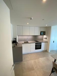 直布罗陀Ardwyn Studio Apartments Gibraltar的厨房配有白色橱柜和水槽