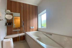 北斗市Guest House Garni Monyamonya - Vacation STAY 83879的一间带大浴缸和窗户的浴室