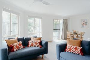 拜伦湾Bayside Court Apartments的客厅设有2张蓝色的沙发和窗户。