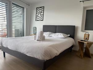 安锡ENTRE NOUS CITY的卧室配有一张带白色床单和枕头的大床。