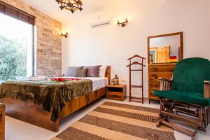 乌尔齐尼COUNTRYSIDE VILLA的一间卧室配有一张床和一把绿色椅子