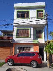 伊基托斯102 RV APARTMENTS IQUITOS-APARTAMENTO FAMILIAR CON PISCINA的停在房子前面的红色汽车