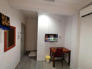 龙运Mi Hotel 2 Dungun的一间设有桌子的房间和墙上的电视