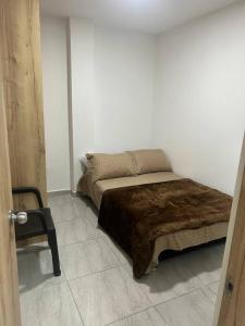 麦德林Lindo apartamento Medellín zona céntrica的一间卧室,卧室内配有一张床和一把椅子